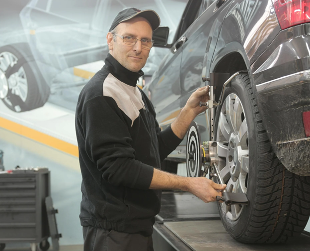 A mechanic checking the tires of a car
