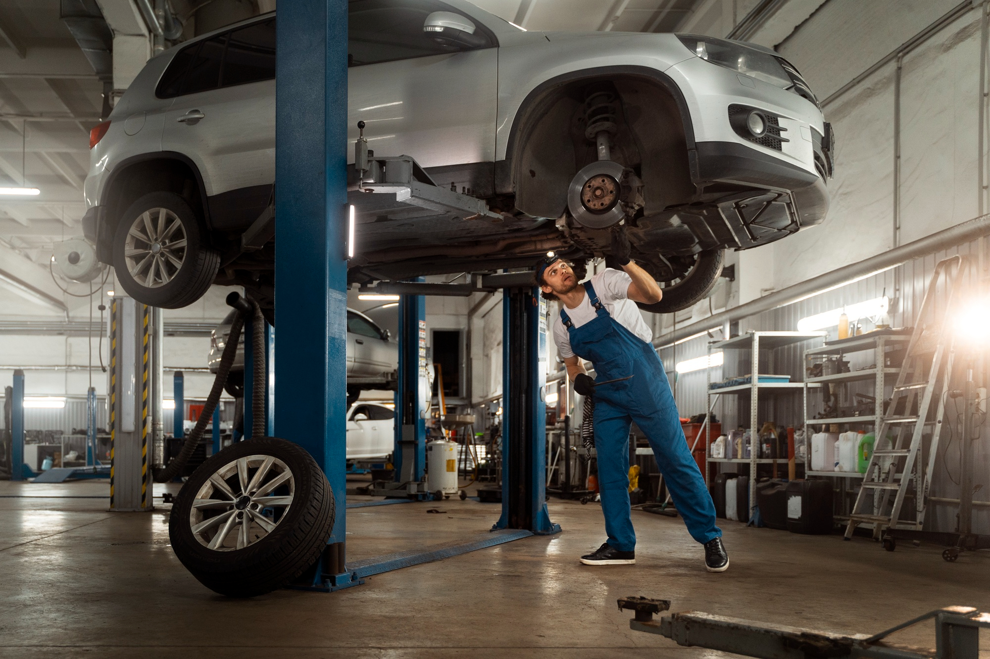 Mechanic inspecting undercarriage of car 